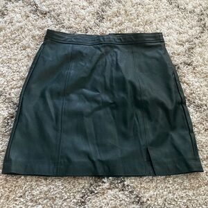 Dark green faux leather skirt with zipper detail in the back.
